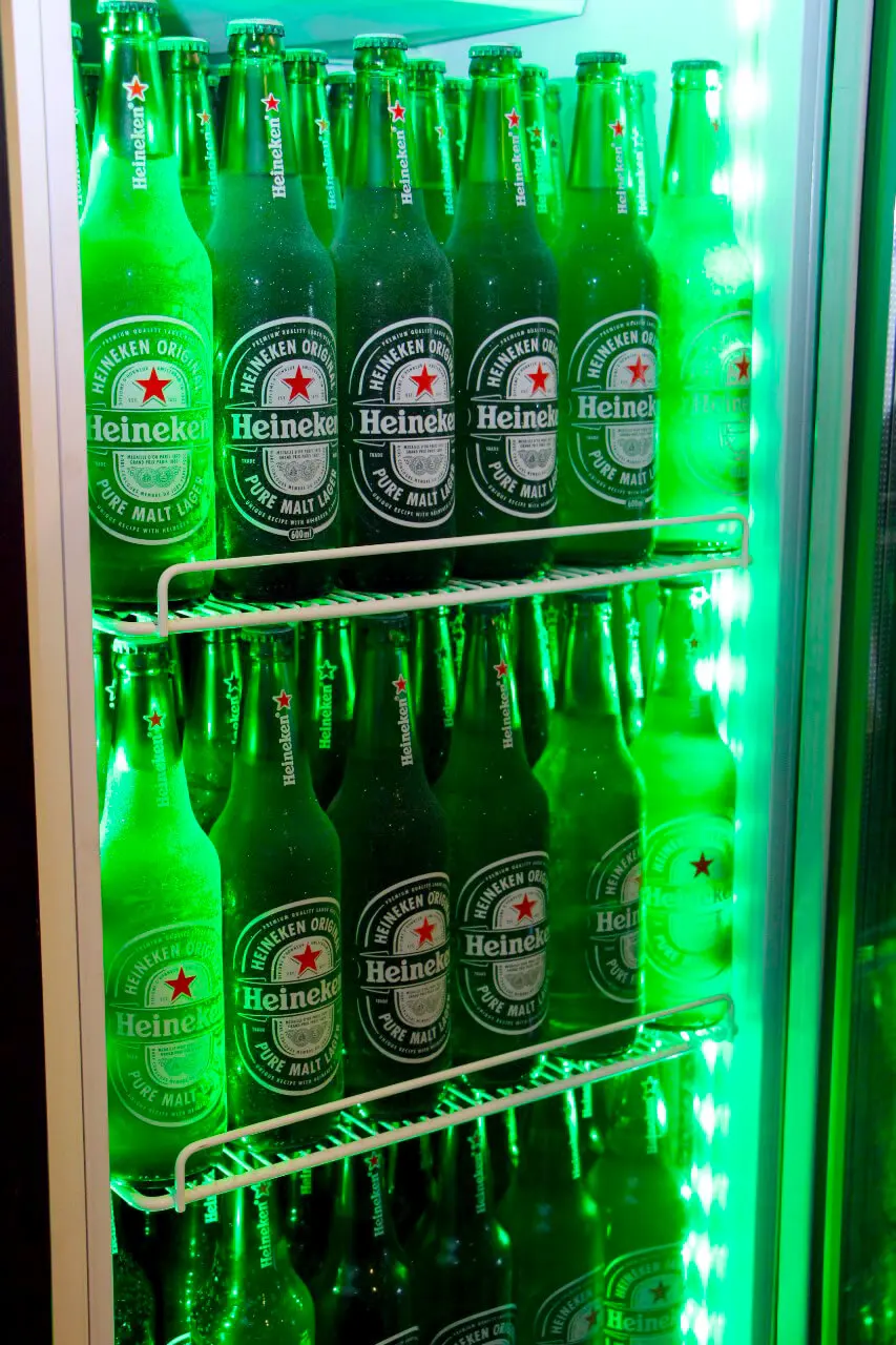 Vitrine refrigerada com garrafas de Heineken iluminadas de verde
