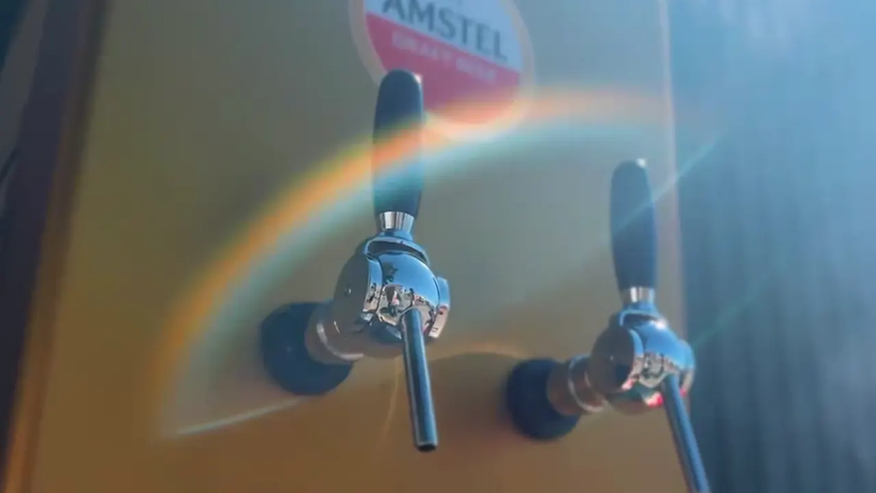 Chopp Amstel sendo tirado na torneira da chopeira, em copo da marca